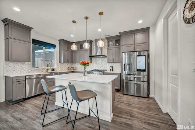 2181 Wyaconda Dr, Sparks, NV 89436 - kitchen featuring appliances with stainless steel finishes, wall chimney range hood, tasteful backsplash, dark wood finished floors, and recessed lighting