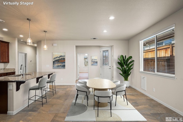 dining room featuring recessed lighting, baseboards, and dark stone finish flooring