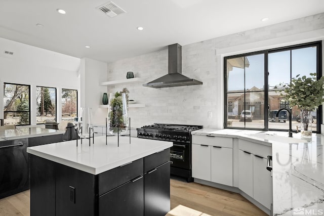 4060 Goodsell Ln, Reno, NV 89523 - kitchen featuring wall chimney range hood, double oven range, dark cabinetry, a sink, and backsplash