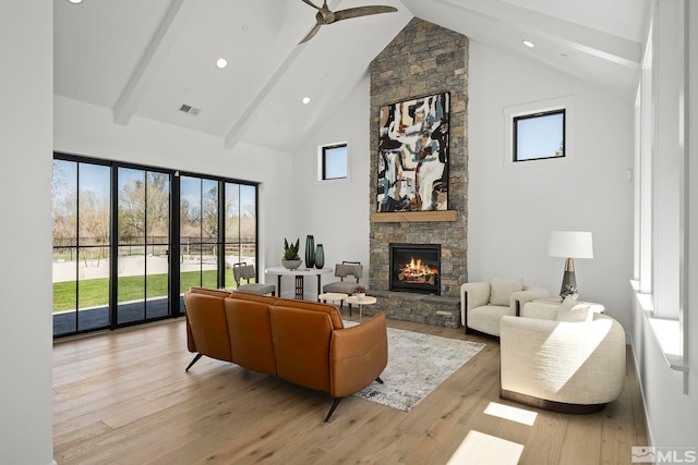 4060 Goodsell Ln, Reno, NV 89523 - living area with a stone fireplace, high vaulted ceiling, beamed ceiling, a ceiling fan, and light wood-style flooring