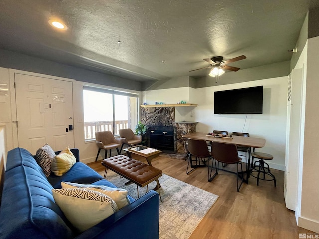 261 Quaking Aspen Ln Unit B, Stateline, NV 89449 - living room featuring baseboards, a ceiling fan, wood finished floors, a fireplace, and a textured ceiling