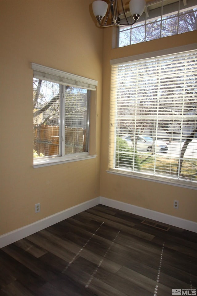 495 Len Cir, Reno, NV 89511 - unfurnished dining area featuring a chandelier, baseboards, and dark wood finished floors