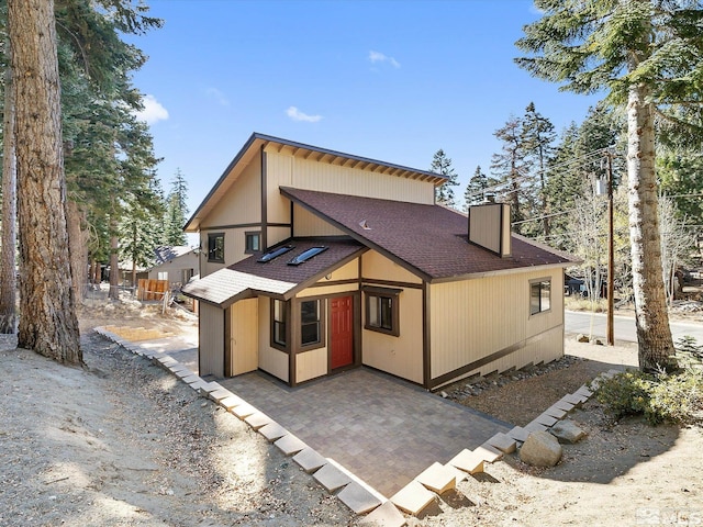 449 Andria Dr, Stateline, NV 89448 - back of property featuring roof with shingles, a chimney, and a patio area