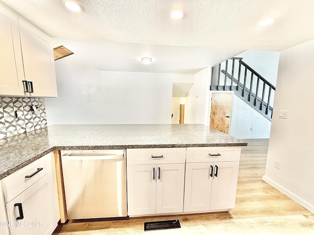 449 Andria Dr, Stateline, NV 89448 - kitchen with dishwasher, a peninsula, light wood-style floors, white cabinetry, and tasteful backsplash