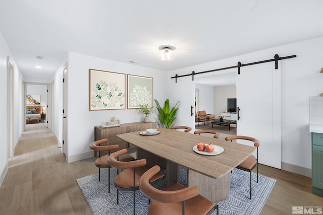 3575 Gull St, Reno, NV 89508 - dining room with a barn door, light wood finished floors, and baseboards