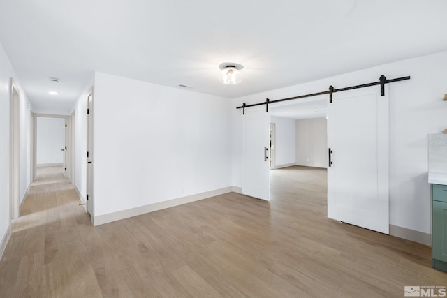 3575 Gull St, Reno, NV 89508 - spare room featuring a barn door, light wood-style floors, and baseboards