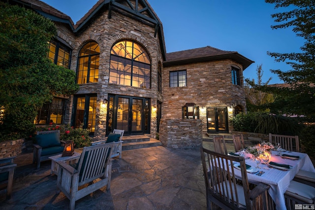 1185 Paddock Ln, Reno, NV 89521 - rear view of house featuring stone siding, french doors, a patio, and outdoor dining space