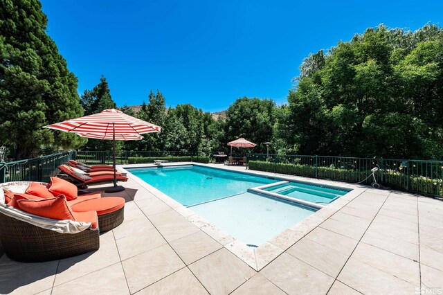 1185 Paddock Ln, Reno, NV 89521 - view of swimming pool with a patio, fence, a pool with connected hot tub, and view of wooded area