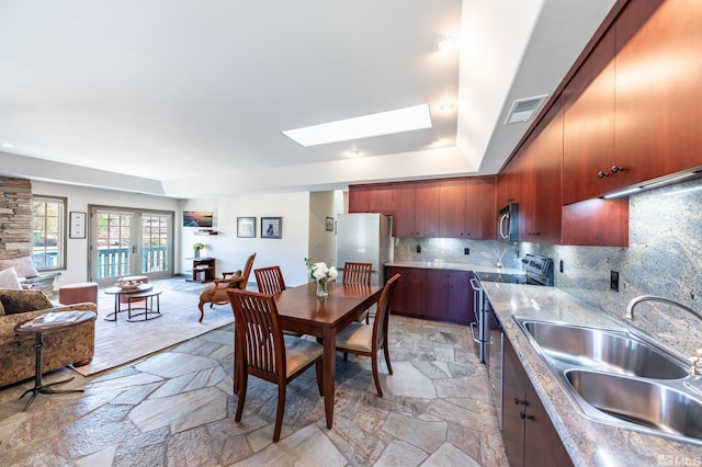 1185 Paddock Ln, Reno, NV 89521 - kitchen with stainless steel appliances, a sink, open floor plan, and light stone finish floors