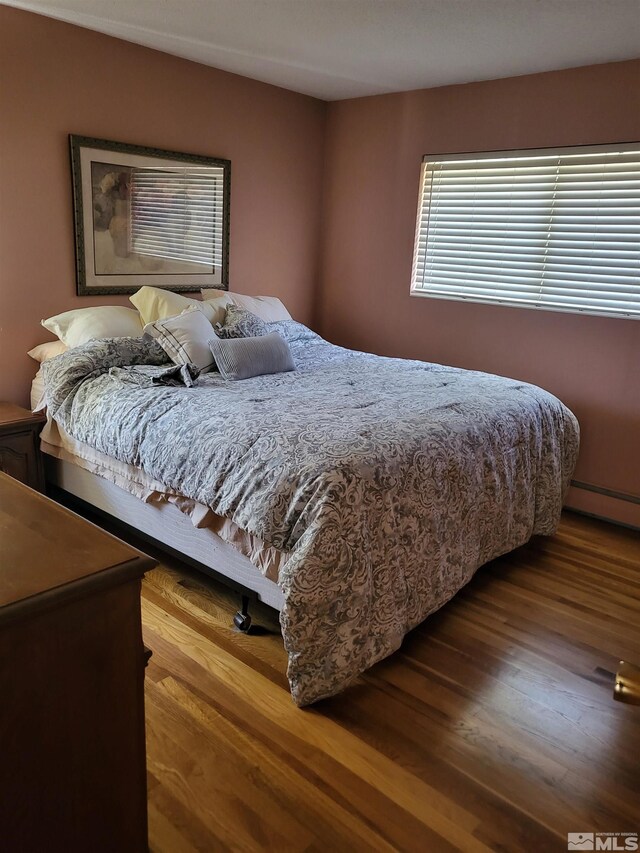 828 W Washington St, Carson City, NV 89703 - bedroom with wood finished floors and a baseboard heating unit