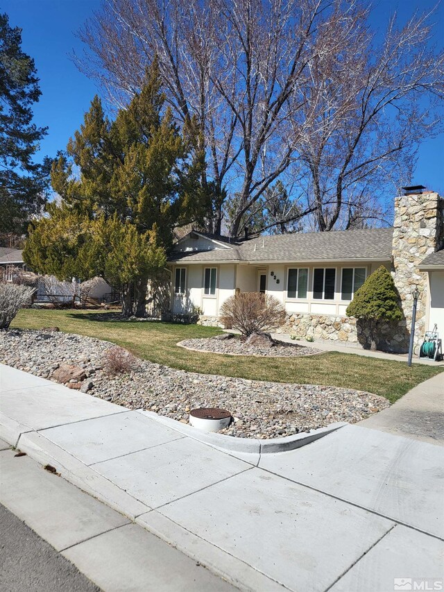 828 W Washington St, Carson City, NV 89703 - view of front of home with a front yard, a chimney, and stucco siding