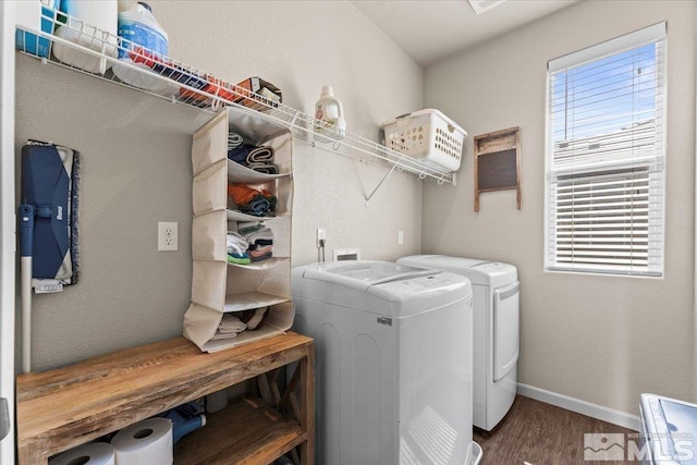 laundry area featuring washing machine and dryer, wood finished floors, and baseboards