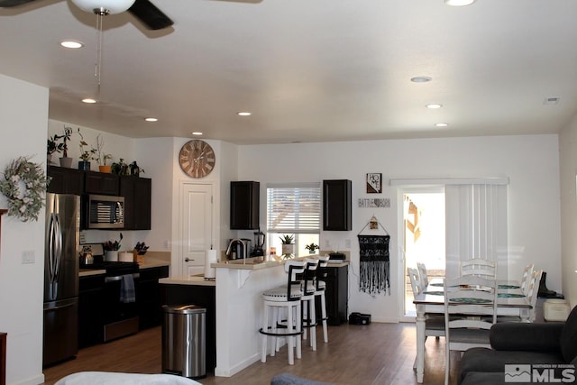 1332 Serenity Cir, Fernley, NV 89408 - kitchen featuring appliances with stainless steel finishes, a breakfast bar, recessed lighting, light countertops, and wood finished floors