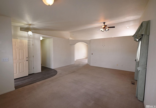 2129 Fort Bridger, Fernley, NV 89408 - unfurnished living room featuring arched walkways, ceiling fan, lofted ceiling, carpet, and baseboards