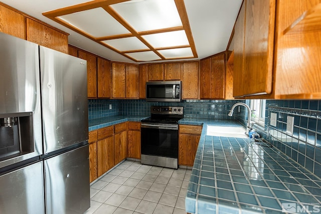2225 Figoni Ranch Rd, Sparks, NV 89434 - kitchen featuring appliances with stainless steel finishes, a sink, tile counters, and brown cabinets