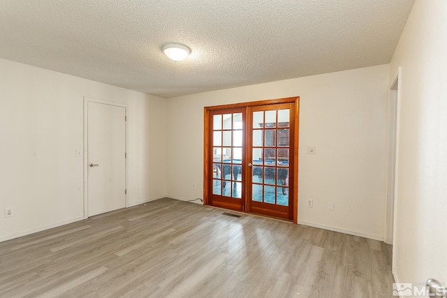 2225 Figoni Ranch Rd, Sparks, NV 89434 - unfurnished room with french doors, light wood-style floors, and a textured ceiling