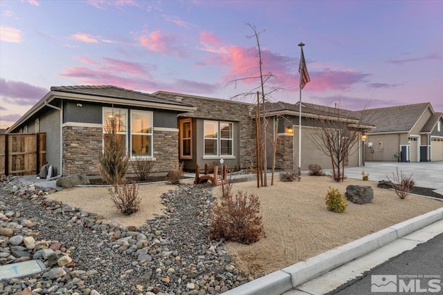 908 Sand Springs Dr, Sparks, NV 89441 - view of front of home with stone siding, concrete driveway, fence, an attached garage, and stucco siding