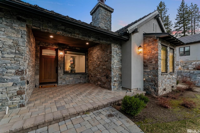 4312 Beaujolais St, Reno, NV 89511 - doorway to property featuring stone siding, a chimney, and stucco siding
