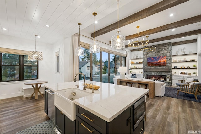 4312 Beaujolais St, Reno, NV 89511 - kitchen featuring a chandelier, dark wood-style floors, a sink, an island with sink, and a stone fireplace