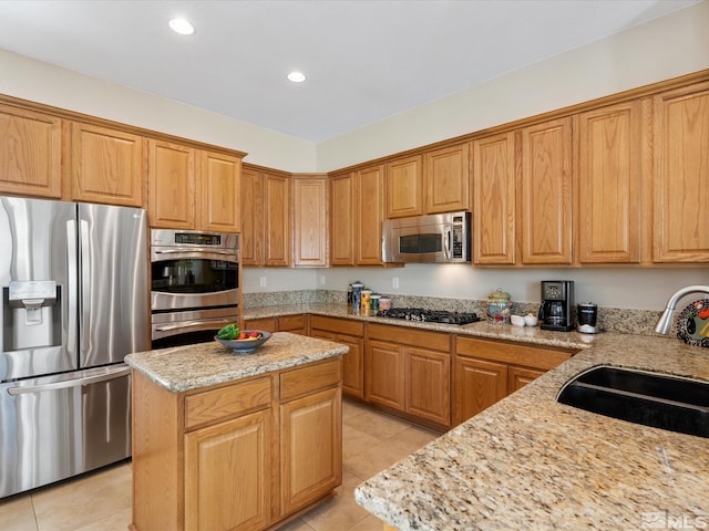 3502 Painted Vista Dr, Reno, NV 89511 - kitchen featuring appliances with stainless steel finishes, a sink, light tile patterned flooring, light stone countertops, and recessed lighting
