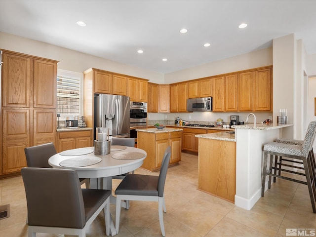 3502 Painted Vista Dr, Reno, NV 89511 - kitchen with stainless steel appliances, a sink, a peninsula, light stone countertops, and recessed lighting