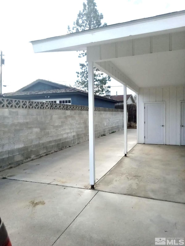 view of patio / terrace featuring fence and a carport