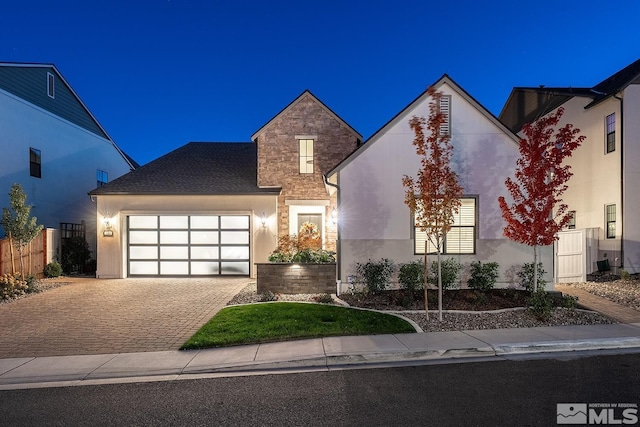 720 Marewood Trl, Reno, NV 89511 - view of front of house with a garage, driveway, stone siding, stucco siding, and fence