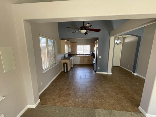 158 Desert Springs Ln, Fernley, NV 89408 - unfurnished living room featuring a ceiling fan, arched walkways, a sink, baseboards, and dark tile patterned floors