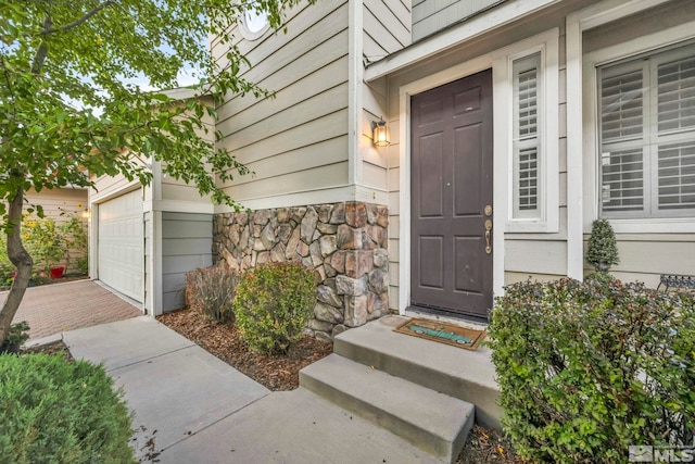 3713 Herons Landing Dr, Reno, NV 89502 - doorway to property featuring stone siding, decorative driveway, and an attached garage