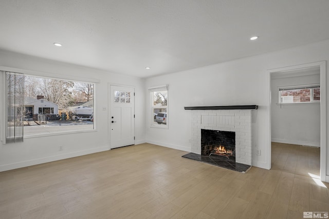 939 Bates Ave, Reno, NV 89502 - unfurnished living room with a fireplace, healthy amount of natural light, light wood-style floors, and recessed lighting