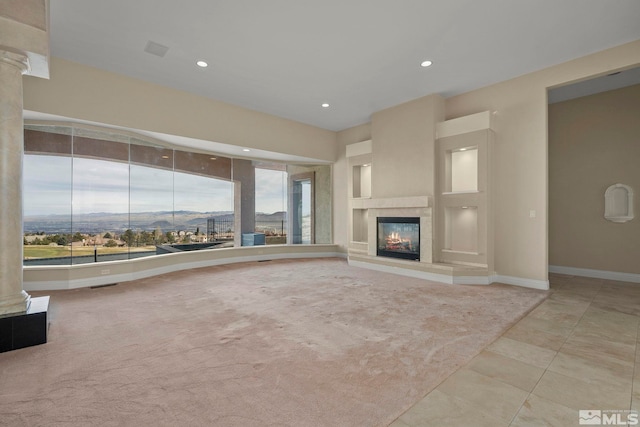 1150 Eagle Vista Ct, Reno, NV 89511 - unfurnished living room with a glass covered fireplace, baseboards, decorative columns, recessed lighting, and tile patterned floors