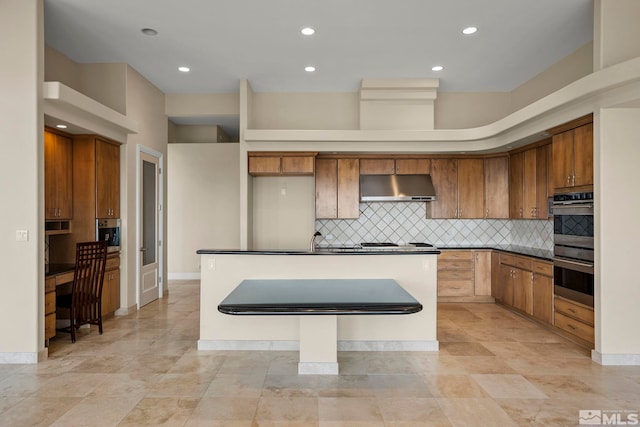 1150 Eagle Vista Ct, Reno, NV 89511 - kitchen featuring under cabinet range hood, a kitchen island, stovetop, tasteful backsplash, and dark countertops