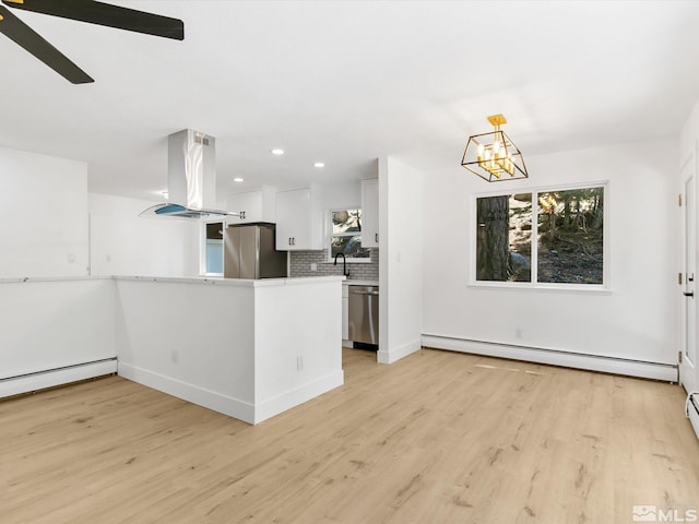 421 Edgewood Dr, Stateline, NV 89449 - kitchen with island range hood, stainless steel appliances, light wood-type flooring, tasteful backsplash, and white cabinetry