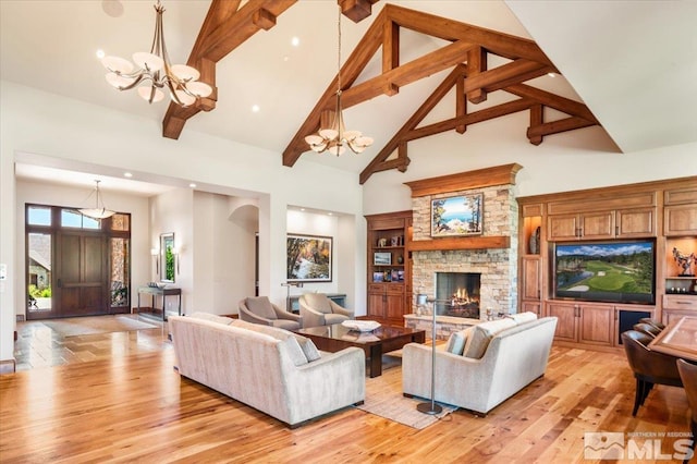 6645 De Chardin Ln, Reno, NV 89511 - living area featuring a chandelier, high vaulted ceiling, a stone fireplace, beamed ceiling, and light wood-style floors