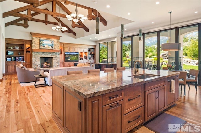 6645 De Chardin Ln, Reno, NV 89511 - kitchen featuring a sink, a kitchen island with sink, a chandelier, pendant lighting, and light wood-style floors
