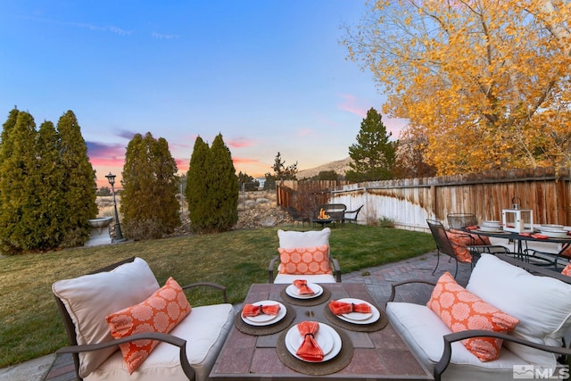 yard at dusk with outdoor dining space and a patio