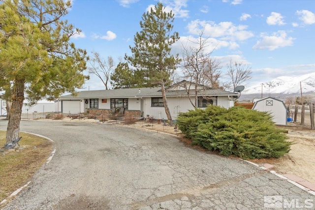 8700 Little Creek Rd, Reno, NV 89508 - ranch-style home with a shed, a garage, a mountain view, and an outbuilding