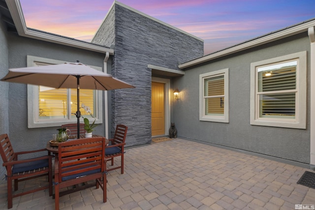 patio terrace at dusk featuring outdoor dining area
