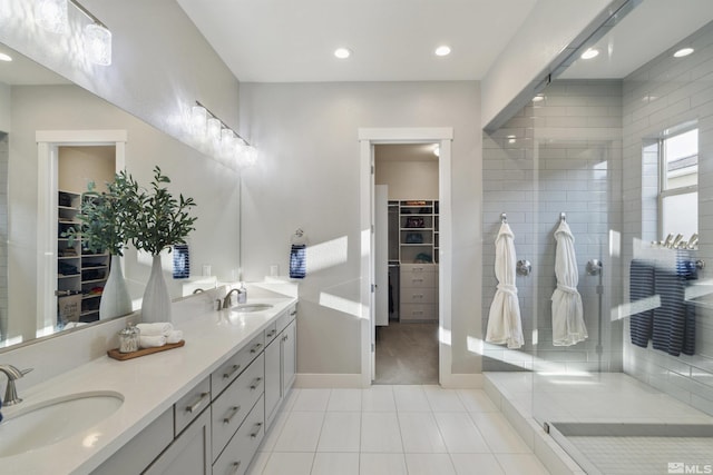 bathroom featuring tile patterned floors, walk in shower, double vanity, a walk in closet, and recessed lighting