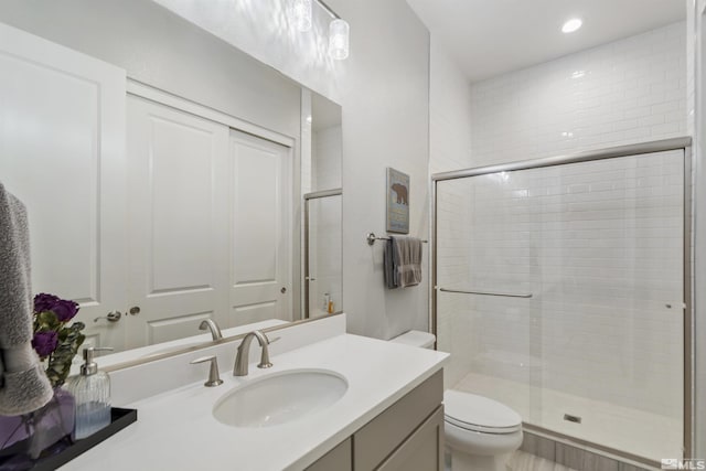 full bathroom featuring toilet, a shower stall, vanity, and recessed lighting