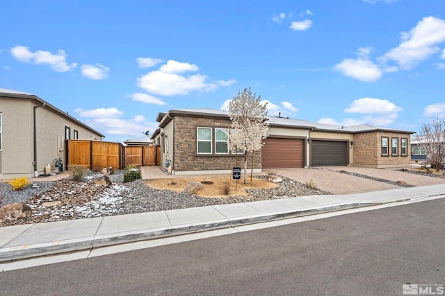7393 Oakmont Ln, Sparks, NV 89441 - view of front of home with a garage, driveway, fence, and stone siding