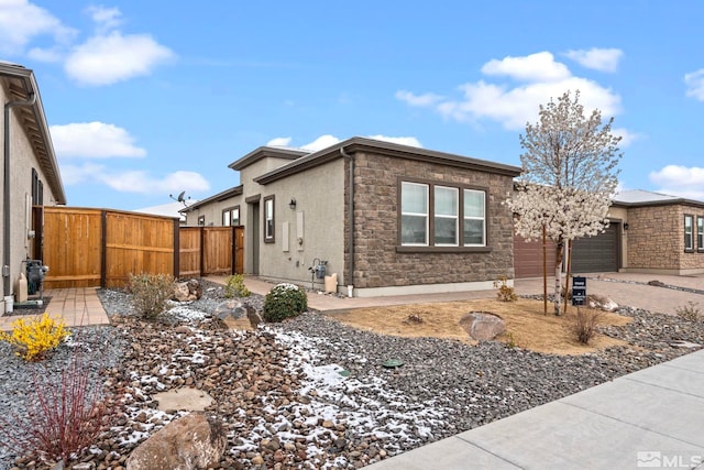 7393 Oakmont Ln, Sparks, NV 89441 - view of property exterior with a garage, fence, stone siding, and concrete driveway