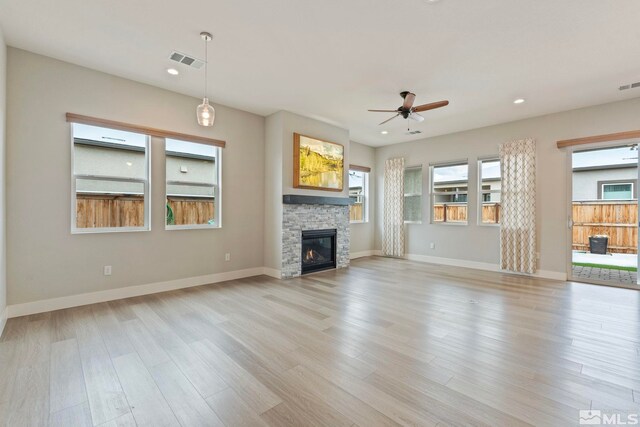 7393 Oakmont Ln, Sparks, NV 89441 - unfurnished living room featuring ceiling fan, a stone fireplace, light wood-style flooring, recessed lighting, and baseboards
