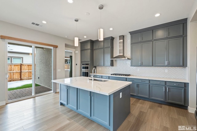 7393 Oakmont Ln, Sparks, NV 89441 - kitchen featuring wall chimney exhaust hood, a sink, gas stovetop, light wood finished floors, and decorative backsplash
