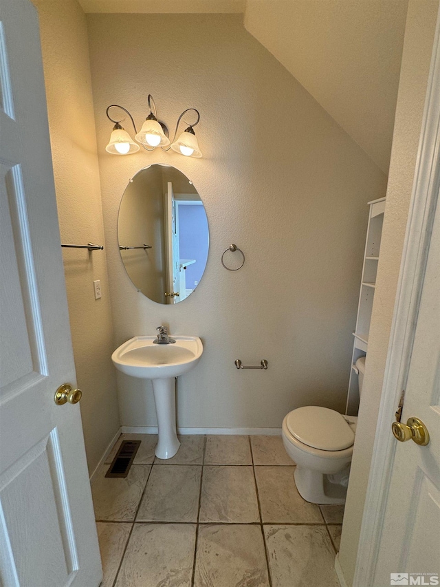 7655 Los Lagos Ave, Sparks, NV 89436 - half bath with tile patterned flooring, toilet, vaulted ceiling, and baseboards