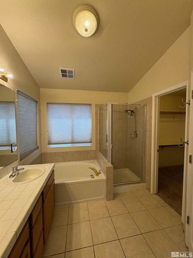 7655 Los Lagos Ave, Sparks, NV 89436 - bathroom featuring lofted ceiling, tile patterned floors, a stall shower, a garden tub, and a spacious closet