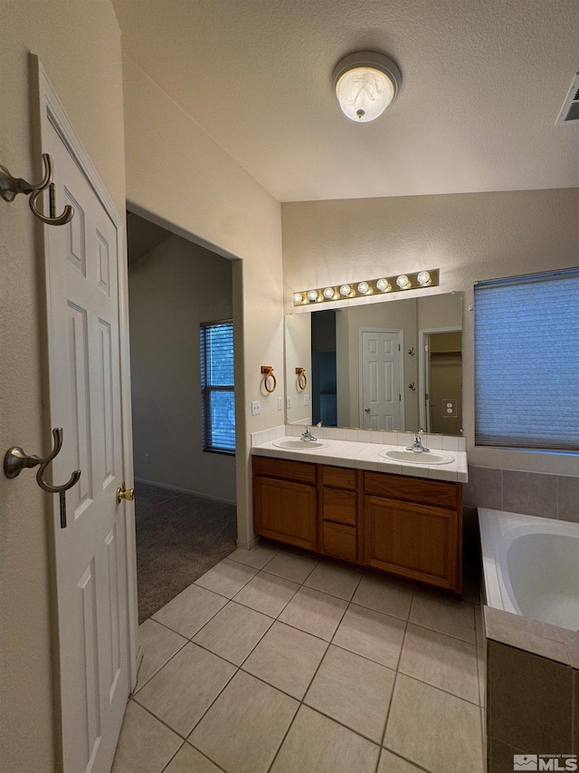 7655 Los Lagos Ave, Sparks, NV 89436 - bathroom with tile patterned floors, double vanity, a bath, and a textured ceiling
