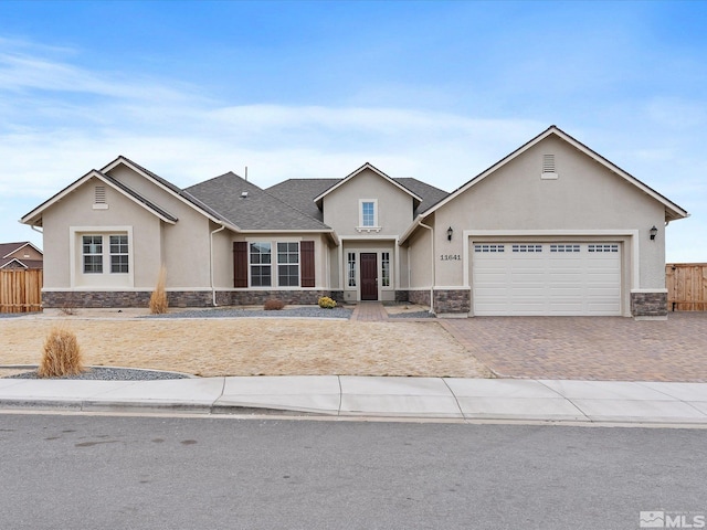 11641 Vista Park Dr, Sparks, NV 89441 - view of front of property featuring stone siding, stucco siding, a garage, decorative driveway, and fence