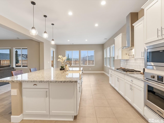 11641 Vista Park Dr, Sparks, NV 89441 - kitchen featuring stainless steel appliances, a sink, wall chimney range hood, white cabinets, and a kitchen island with sink