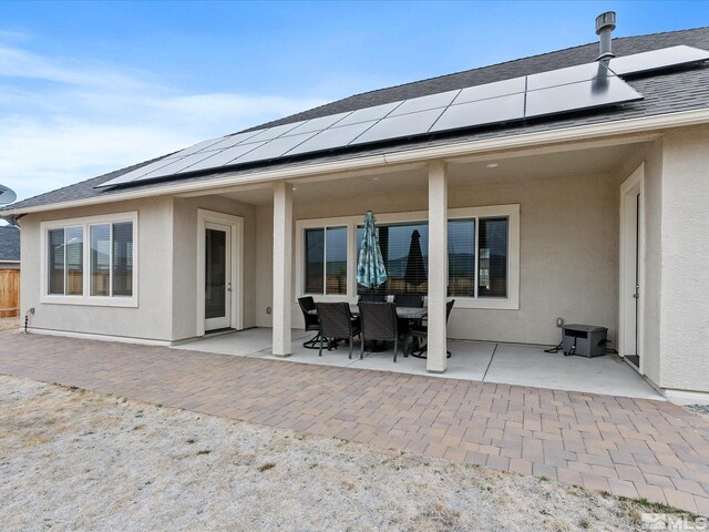 11641 Vista Park Dr, Sparks, NV 89441 - back of property with stucco siding, a patio area, roof mounted solar panels, and outdoor dining area